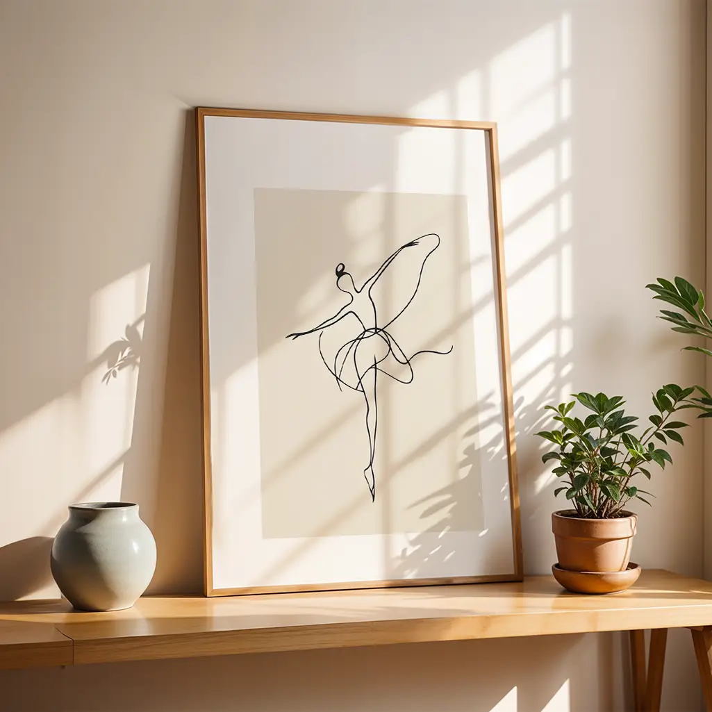 Framed ballerina line art print on a wooden shelf with a plant and vase, sunlight casting geometric shadows.