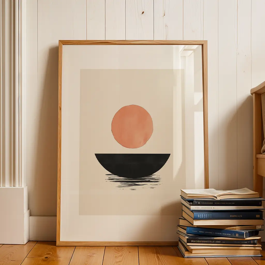 Framed Japandi print on a wooden floor against a white wall, next to a stack of books and a wooden chair.